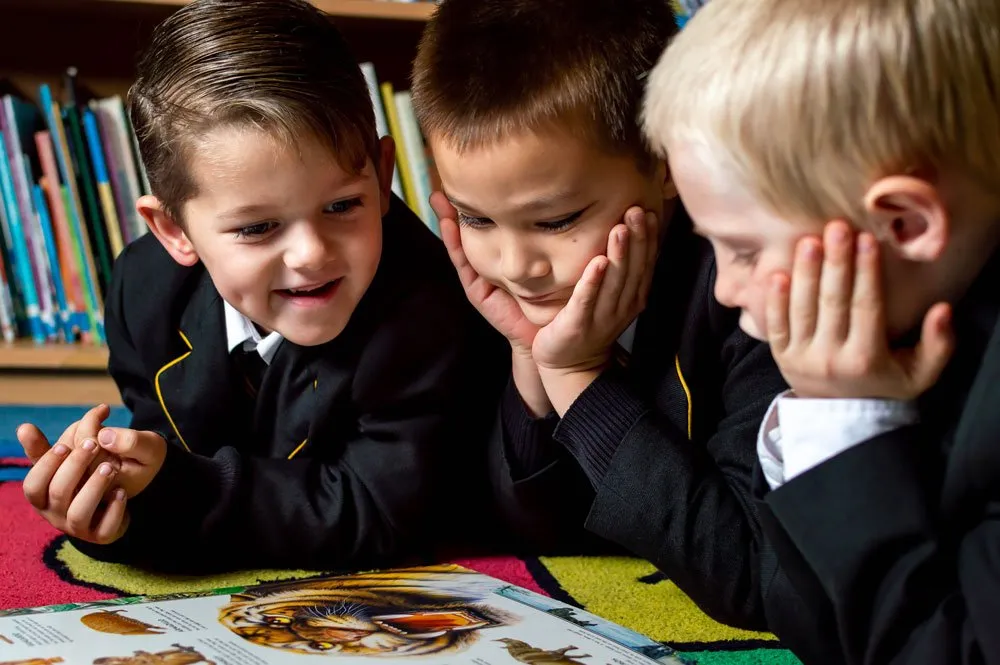 school children reading a book