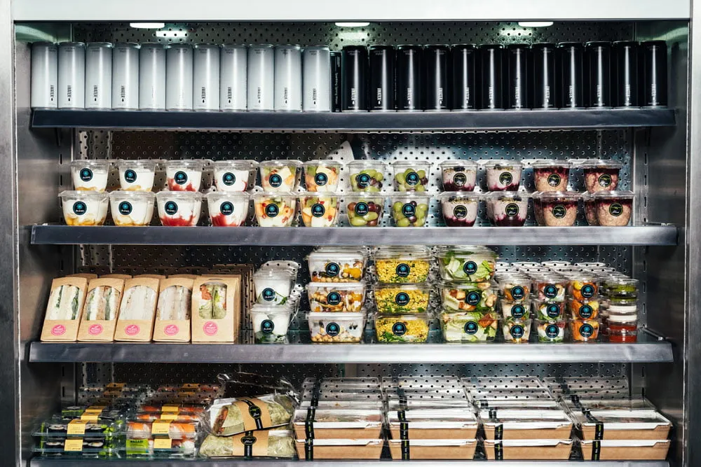 sandwiches and salads stacked in supermarket refrigerator