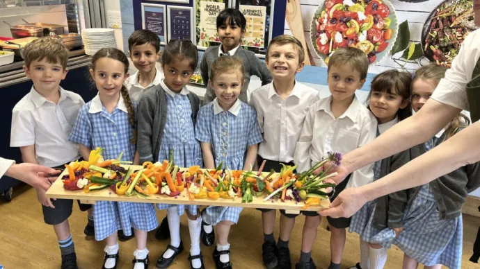 school children with a tray of vegetables